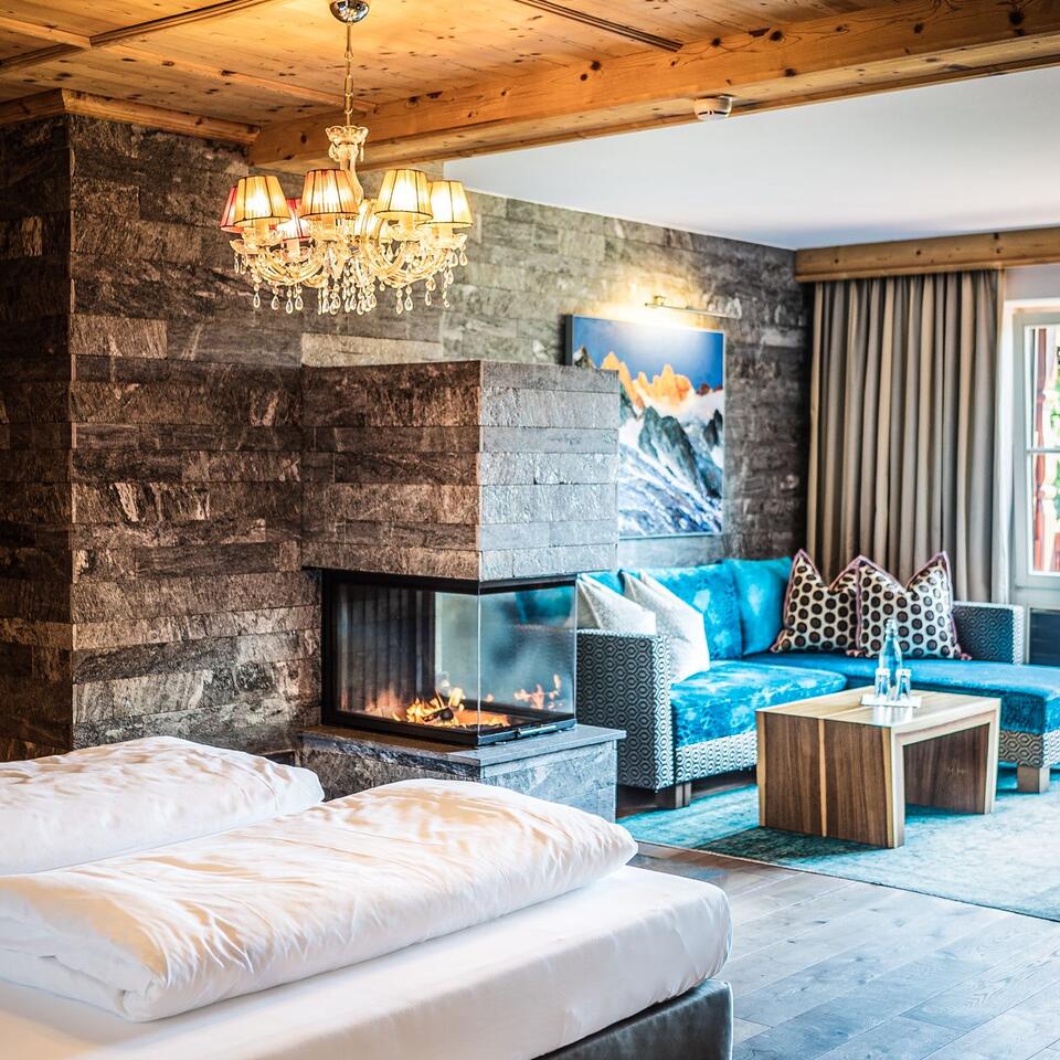 Gemütliches Hotelzimmer mit Kamin, Sofa und Doppelbett