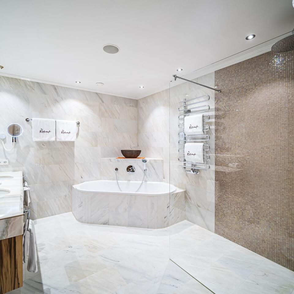 Modernes Badezimmer mit Marmor, Badewanne und Handtuchwärmer