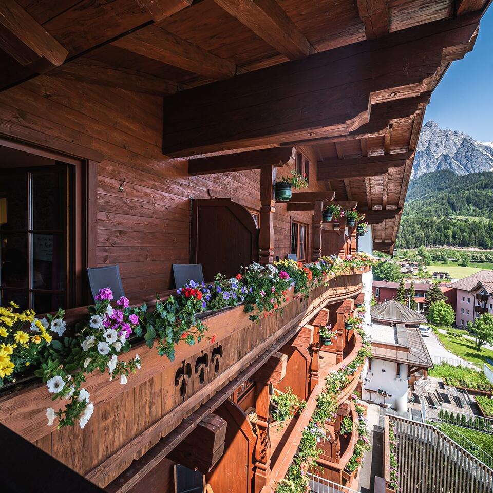 Holzbalkon mit Blumenkästen, Blick auf Berglandschaft