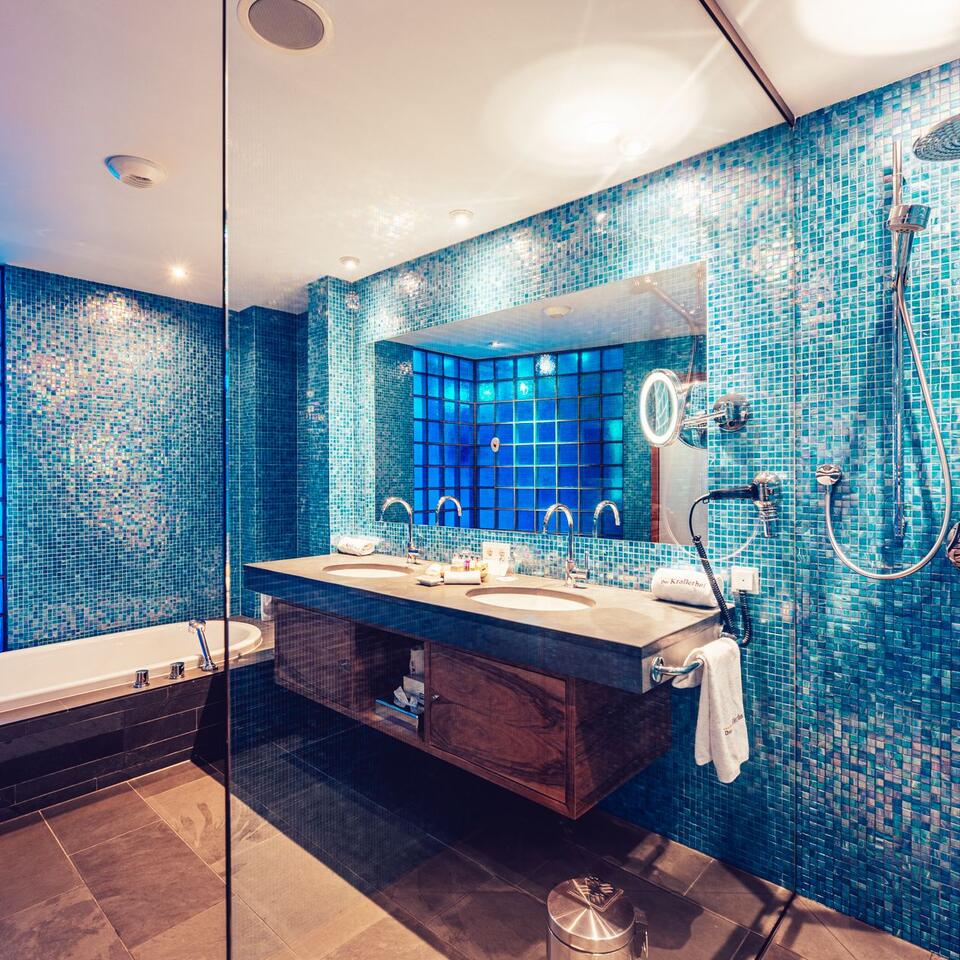 Modernes Badezimmer mit blauen Mosaikfliesen, Doppelwaschbecken und Badewanne