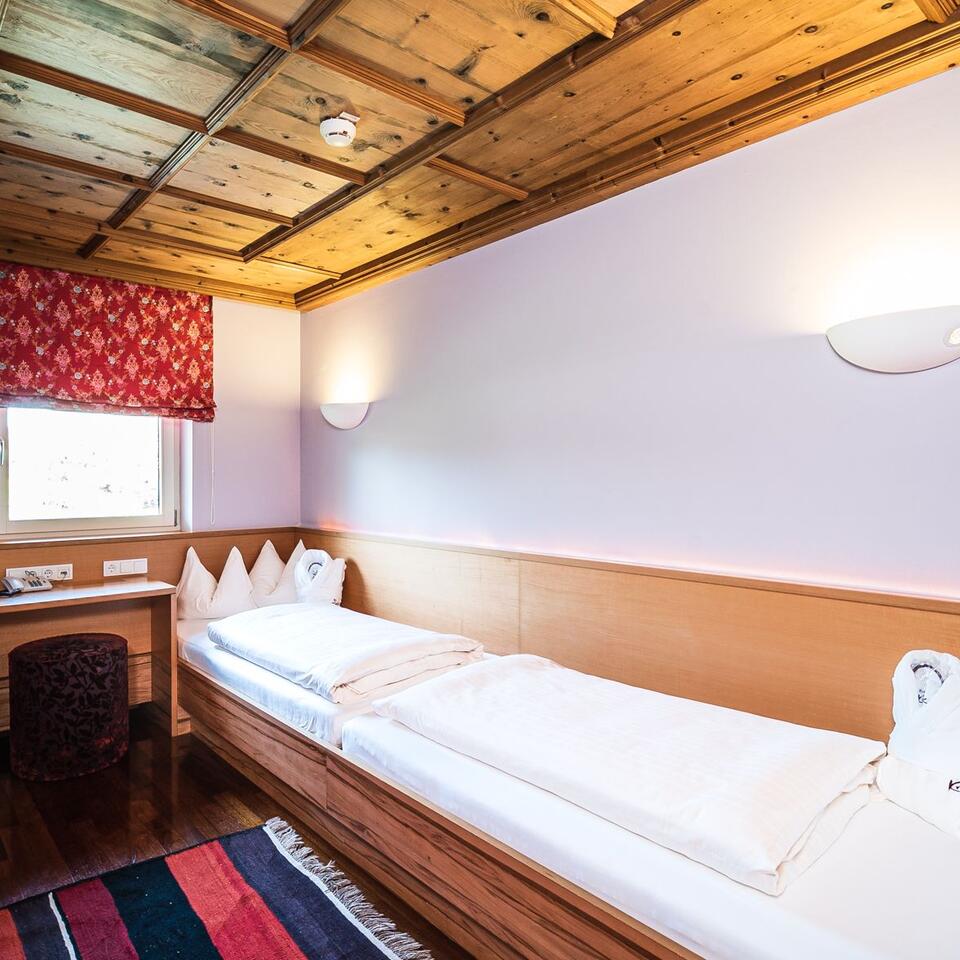 Bedroom with single bed, wooden ceiling and small window