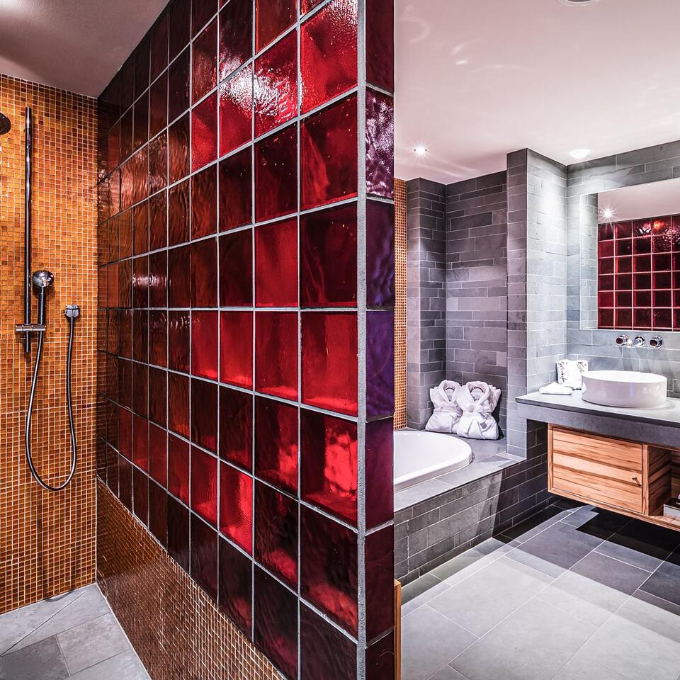 Modern bathroom with red glass tile wall and shower