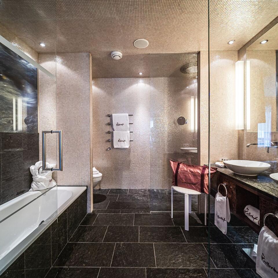 Modernes Badezimmer mit Badewanne, Dusche und dunklen Fliesen