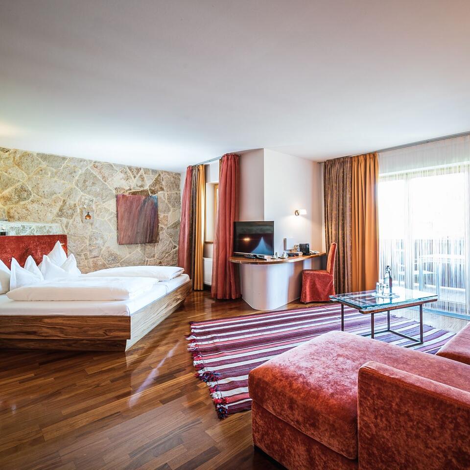 Hotel room with bed, desk, TV, sofa and balcony