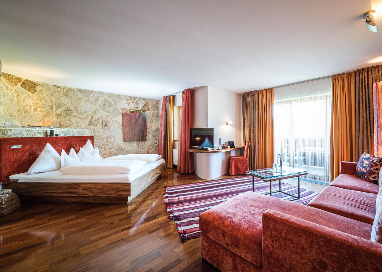 Hotelzimmer mit Bett, Schreibtisch, Fernseher, Sofa und Balkon