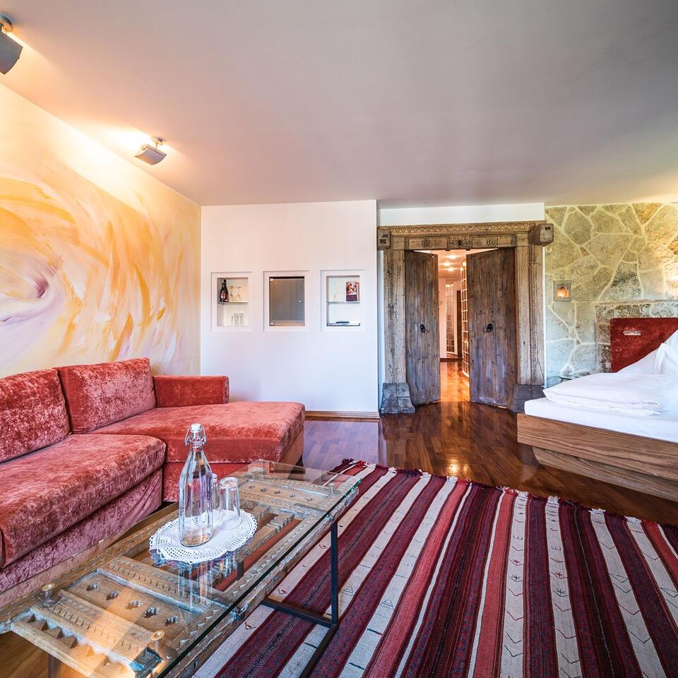 Cozy room with red sofa, carpet, wooden doors and double bed