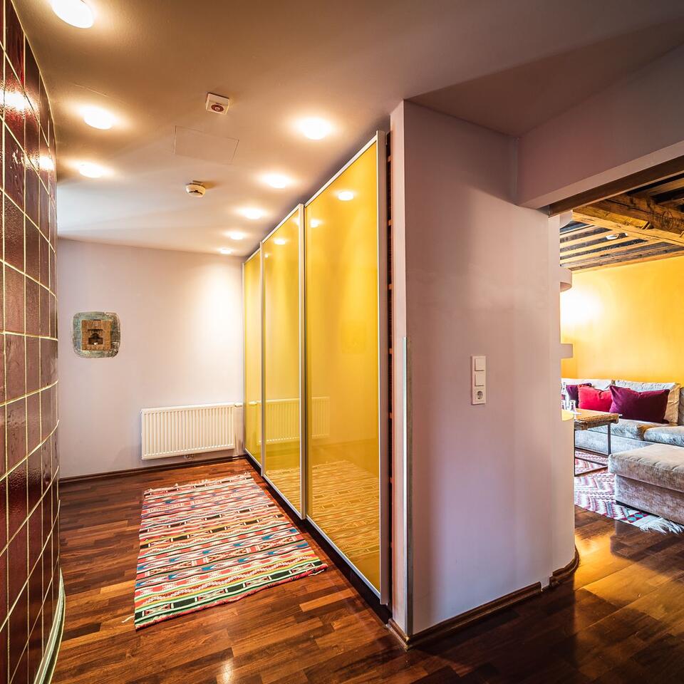 Hallway with yellow sliding doors, wooden floor and carpet leads into a living room