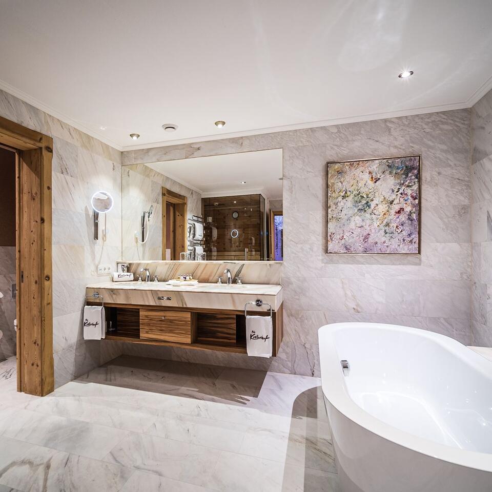 Modernes Badezimmer mit Marmor, Waschtisch, Spiegel und freistehender Badewanne