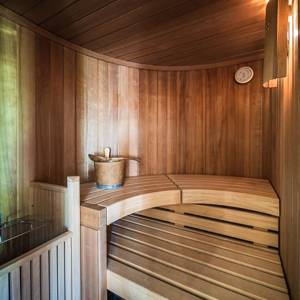 Holzsauna mit Bänken, Eimer und Thermometer