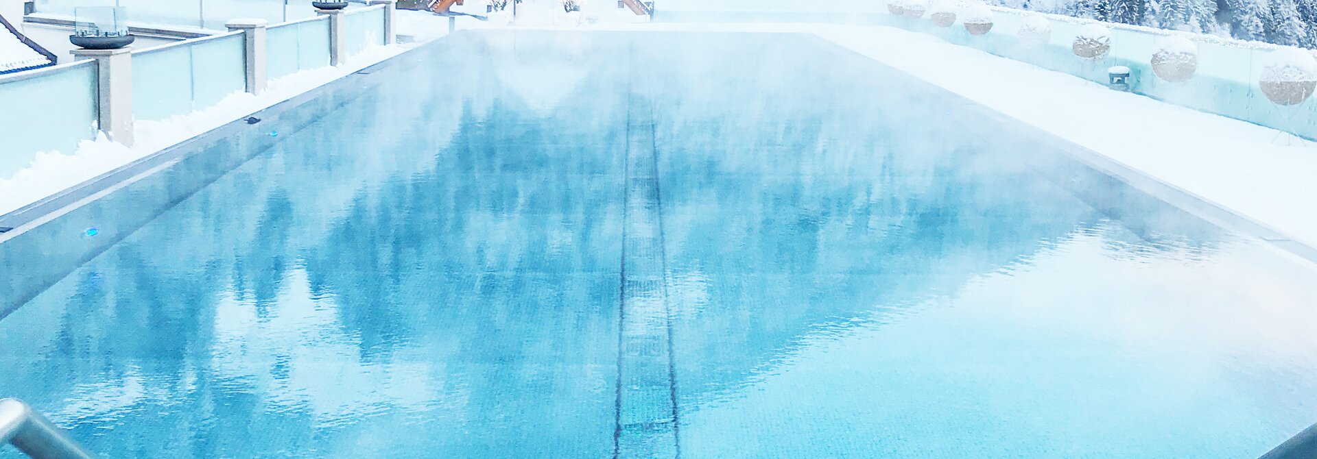 Beheizter Pool vor verschneiter Berglandschaft in Tirol