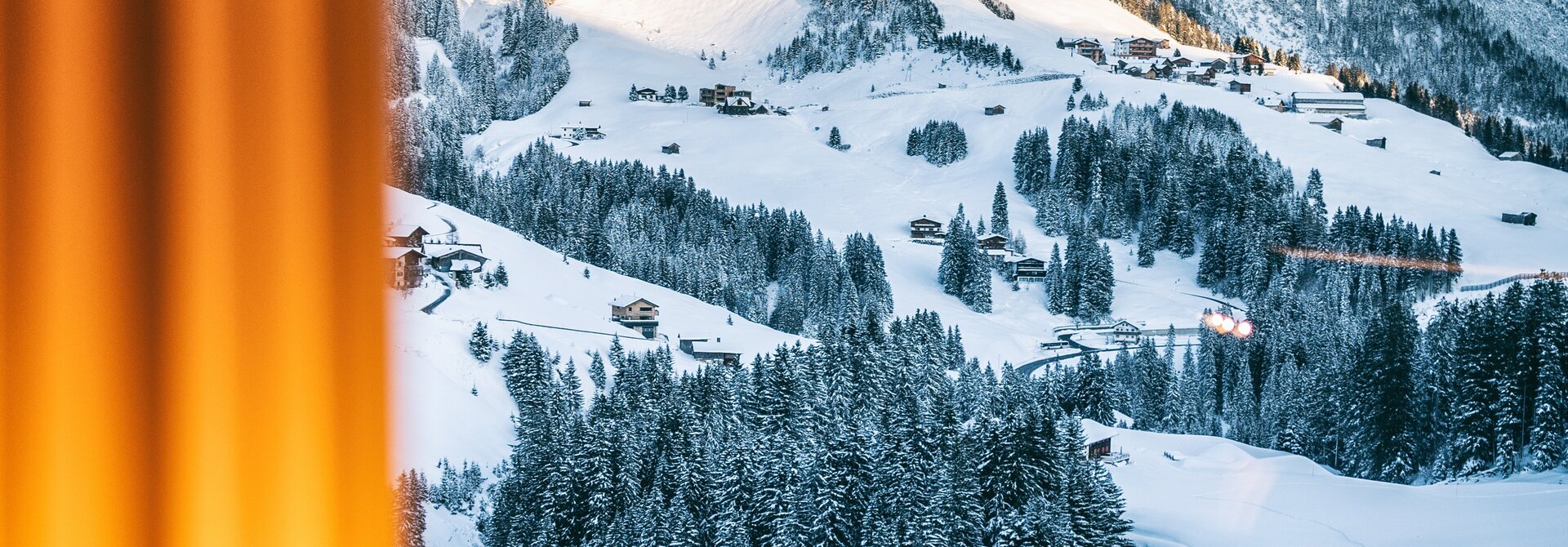 Snowy landscape in Vorarlberg with mountains, trees and houses in winter