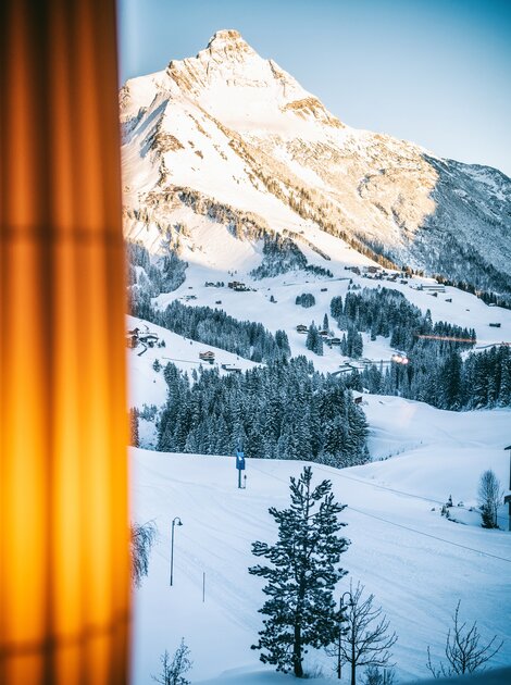 Verschneite Landschaft in Vorarlberg mit Bergen, Bäumen und Häusern im Winter